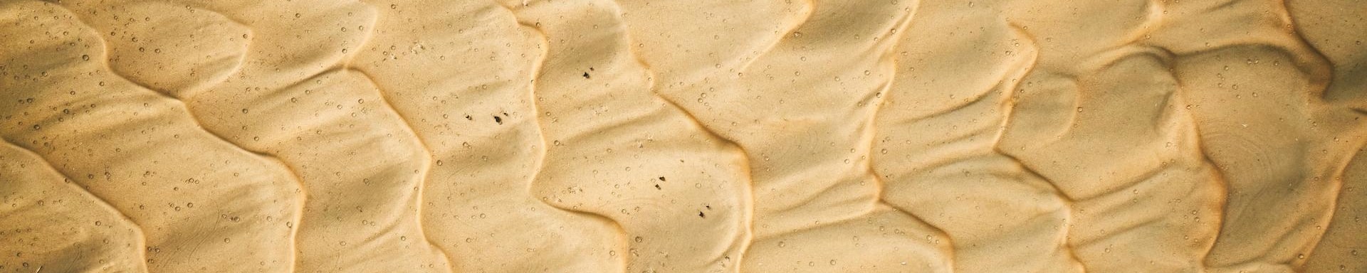 Eine Nahaufnahme von Sand am Meer. Symbolbild für das Relationship Management im Transaction Banking.