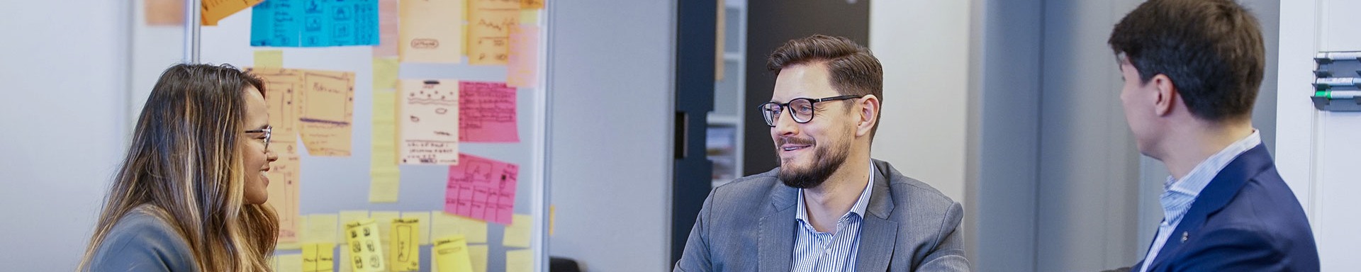 Mitarbeiter des Transaction Banking Teams sitzen in einem Meetingraum und unterhalten sich über ihre Karrieren bei der Bank Vontobel.