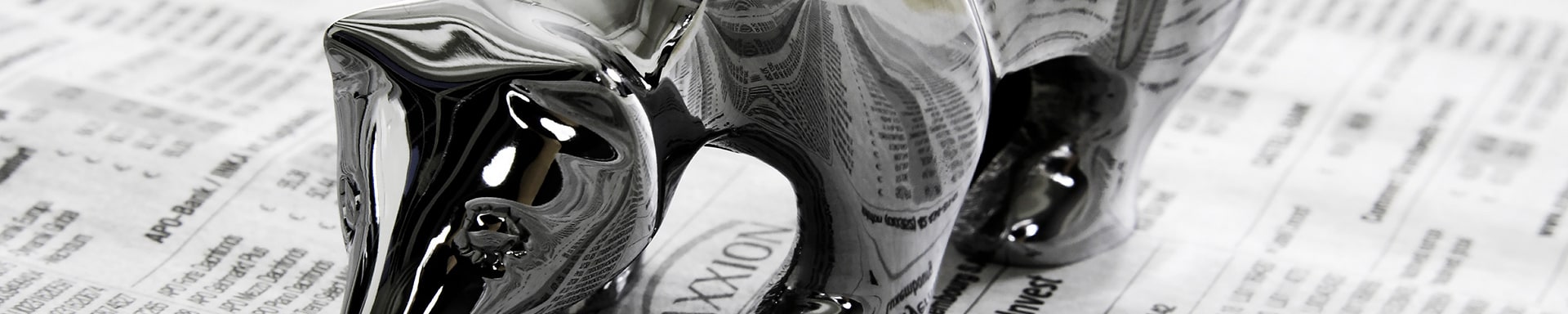 Silver bear figurine on a financial newspaper, symbolizing a bearish market outlook.