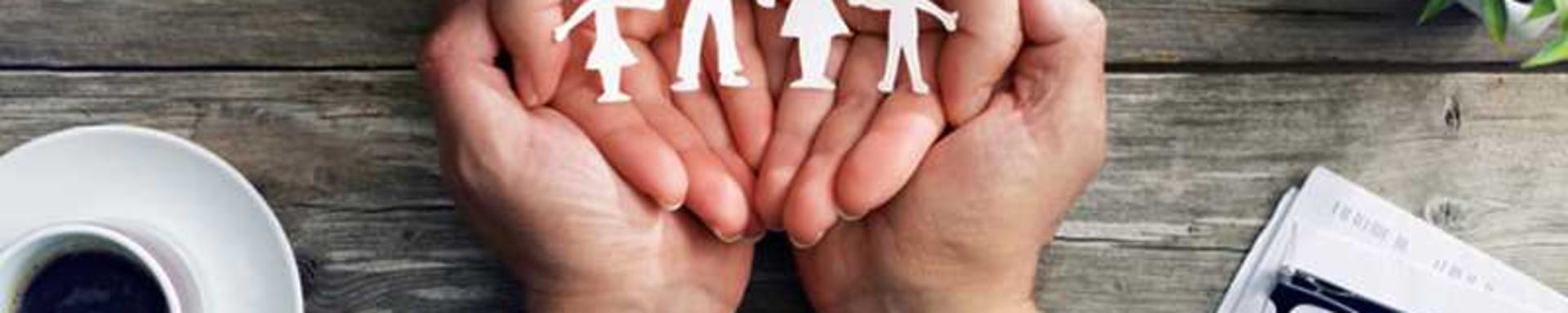 Eine Familie hält fröhlich Papierausschnitte von sich selbst, die ihre Einheit und Liebe symbolisieren.