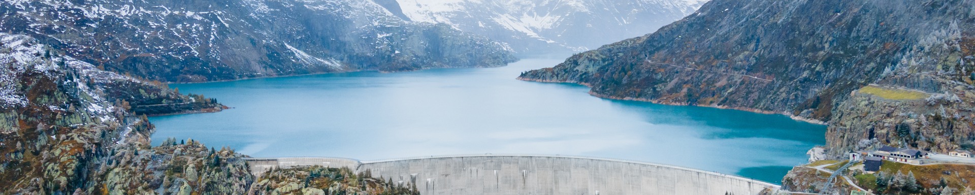 Mountain scenery with a large reservoir dam and bright blue water
