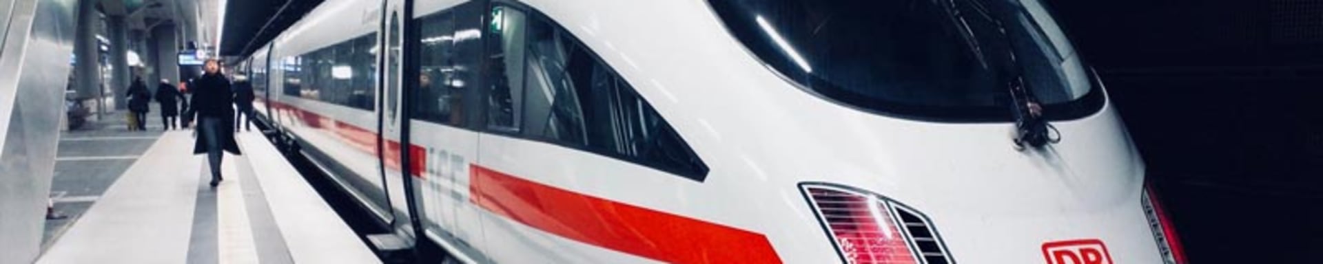 Un treno veloce bianco e rosso parcheggiato in una stazione, pronto a trasportare i passeggeri a destinazione.