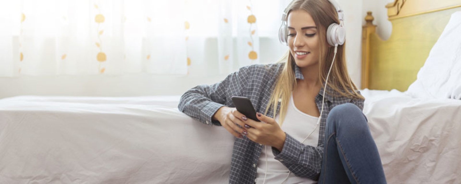 A woman sitting on the floor with headphones and a laptop symbolize gen-z.