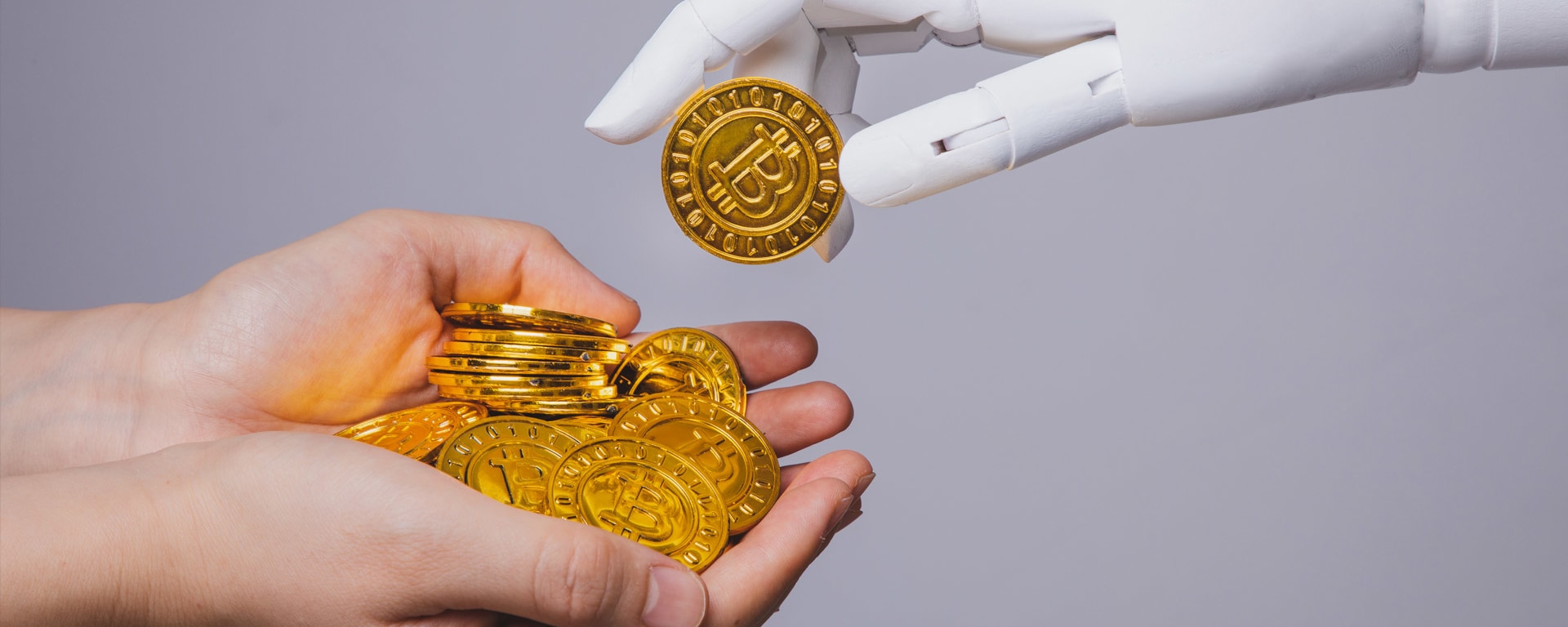 Eine Roboterhand legt Bitcoins in die Hände eines Menschen.