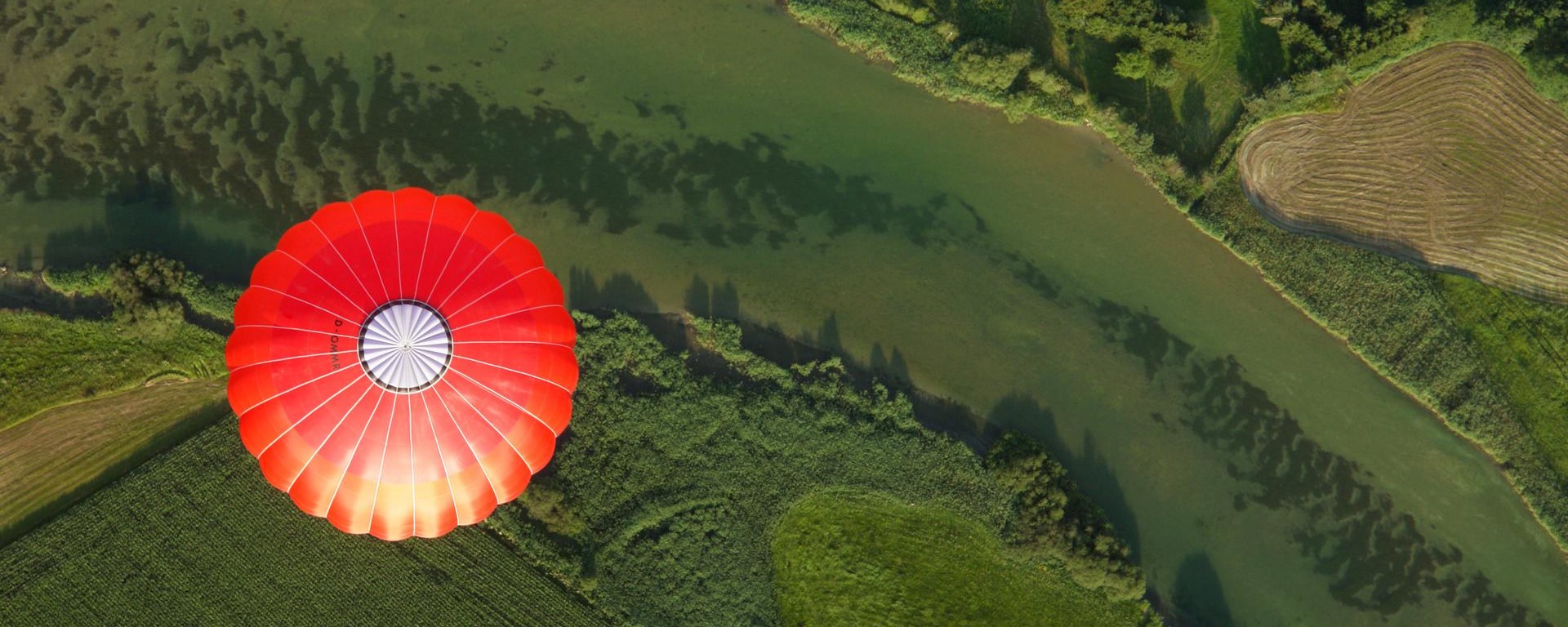 Picture of a hot red air baloon with a green background.
