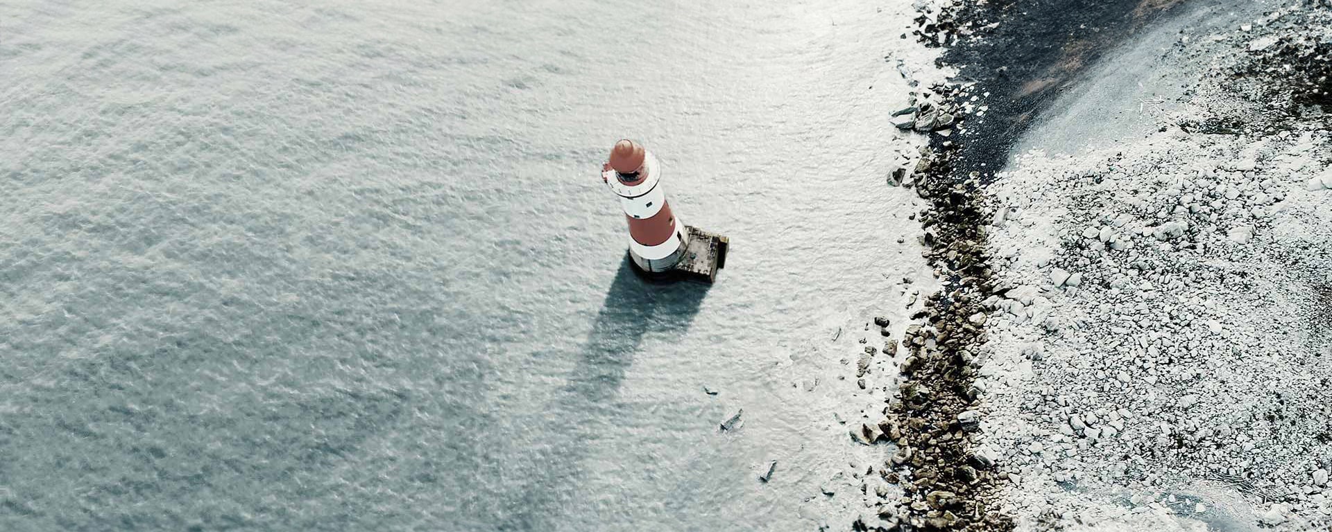 Ein Bild eines Leuchtturms mittem im Meer.