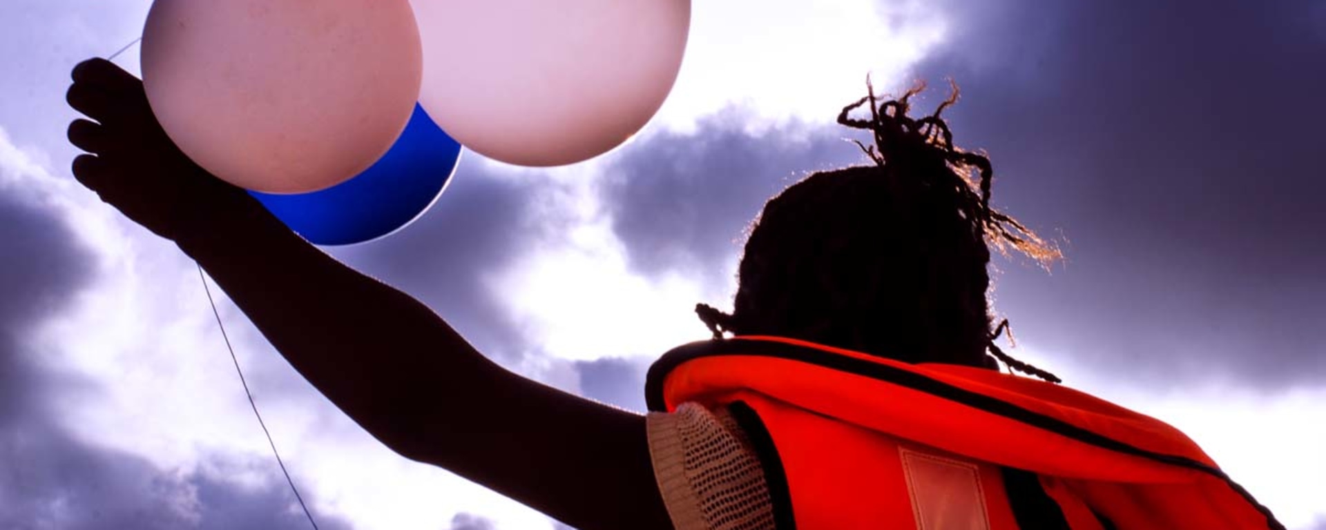 A New Gaze 2 Gallery - Frog perspective of a woman holding seven balloons.