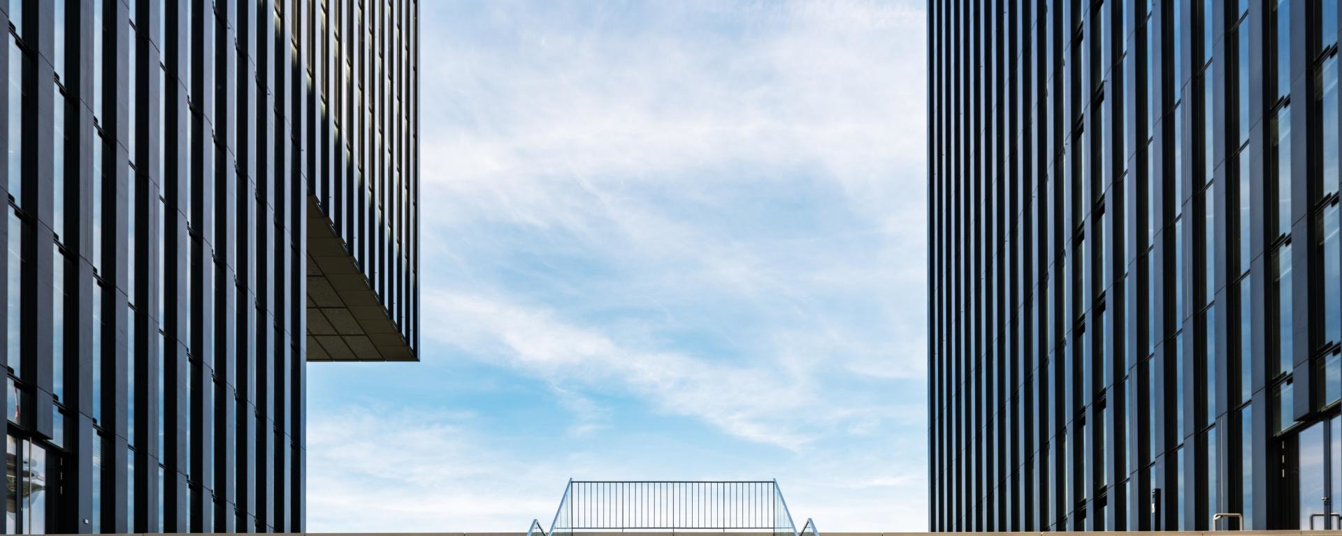 Broad staircase leading between modern office buildings, illustrating a review of recent market performance and the key investment drivers shaping the path forward