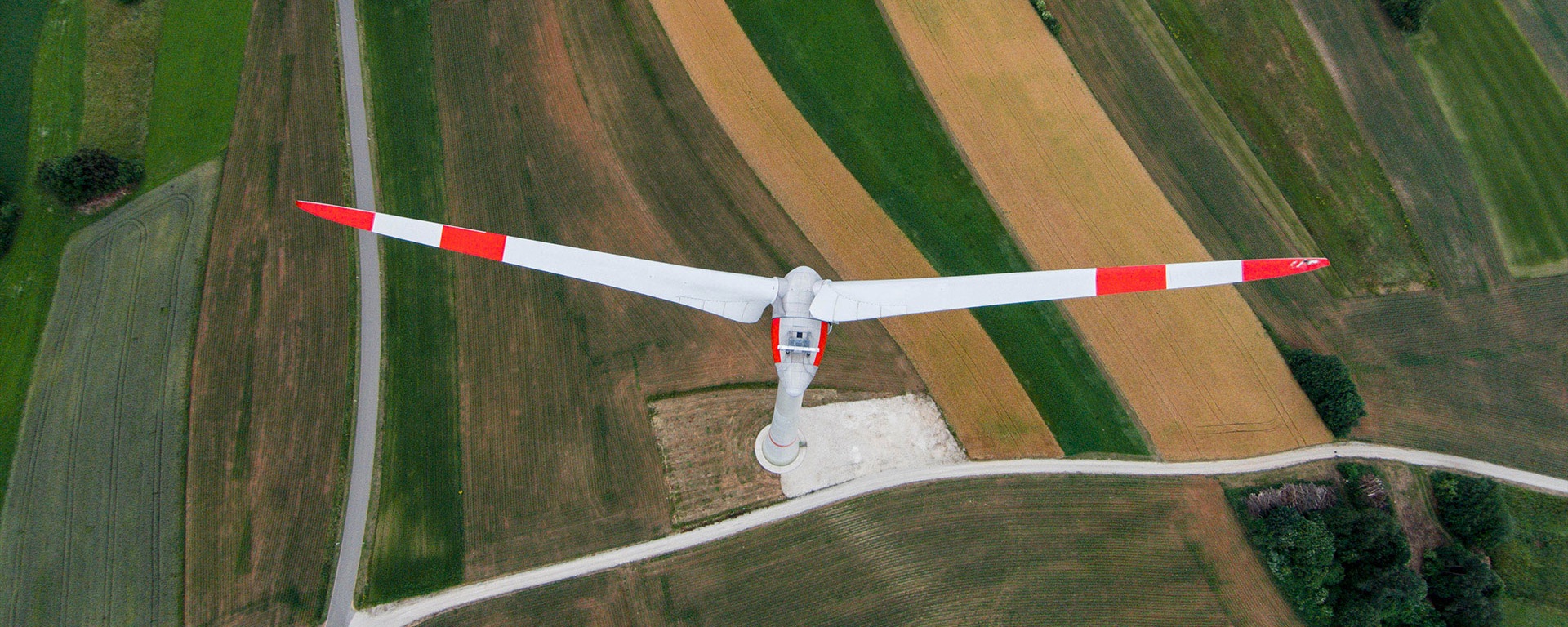 Vogelperspektive einer Windturbine auf einem grünen Feld.