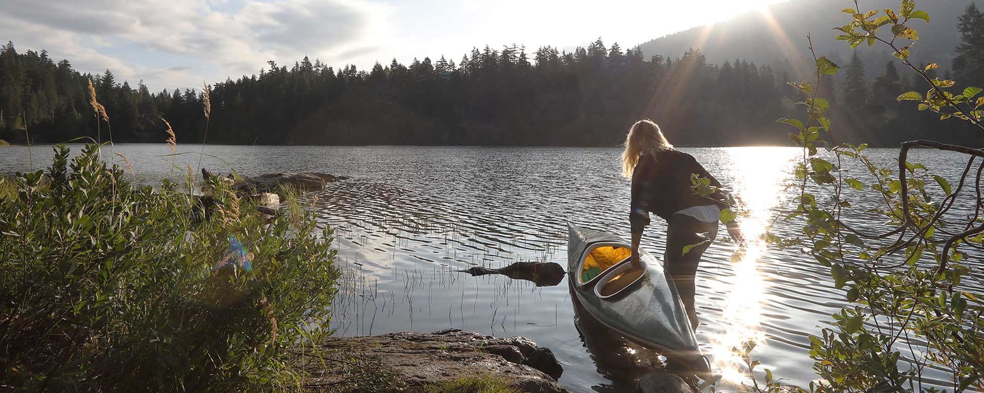 Une femme monte dans un canoë au bord d'un lac
