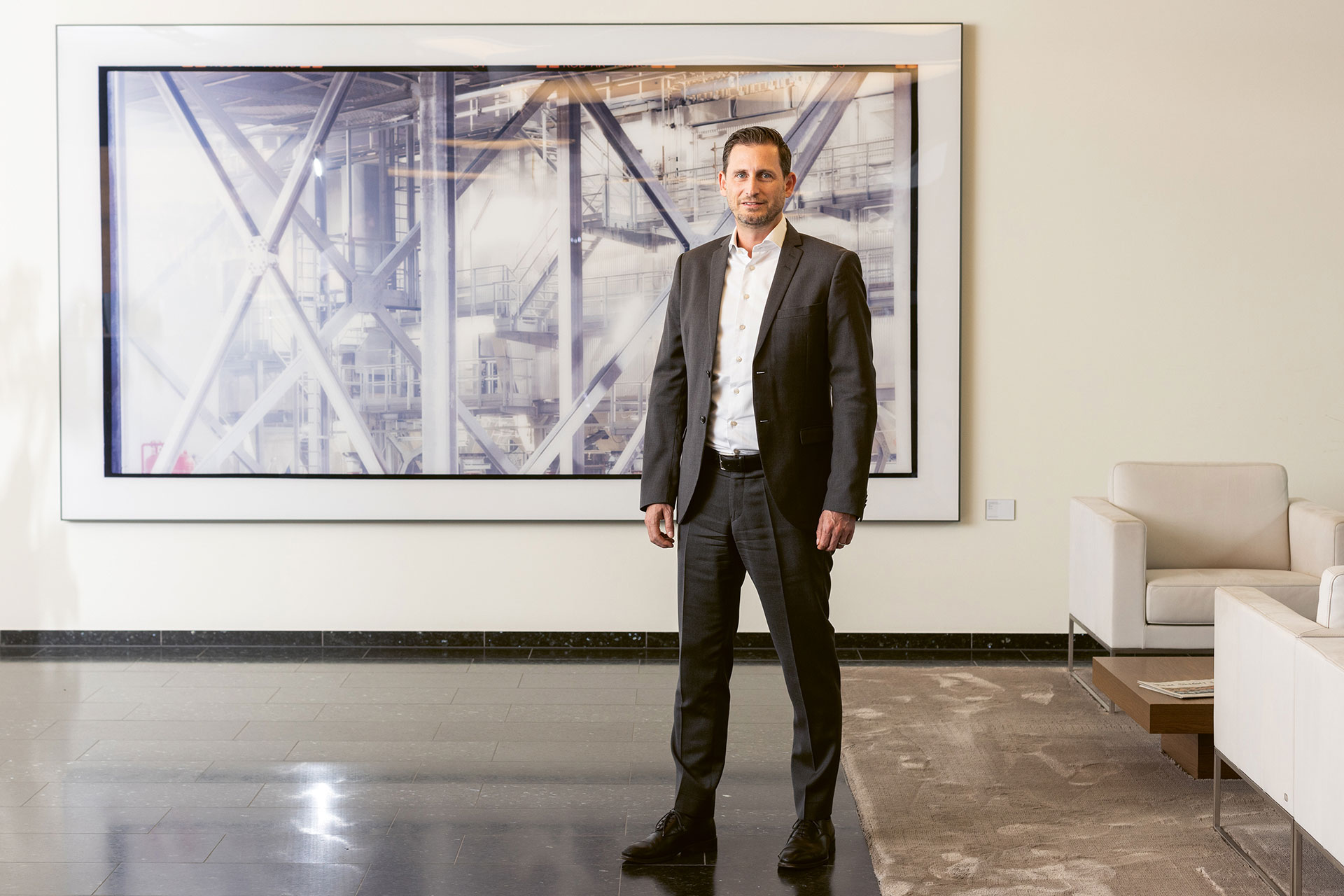An employee of the Transaction Banking team stands in front of a painting at the headquarters of Bank Vontobel.