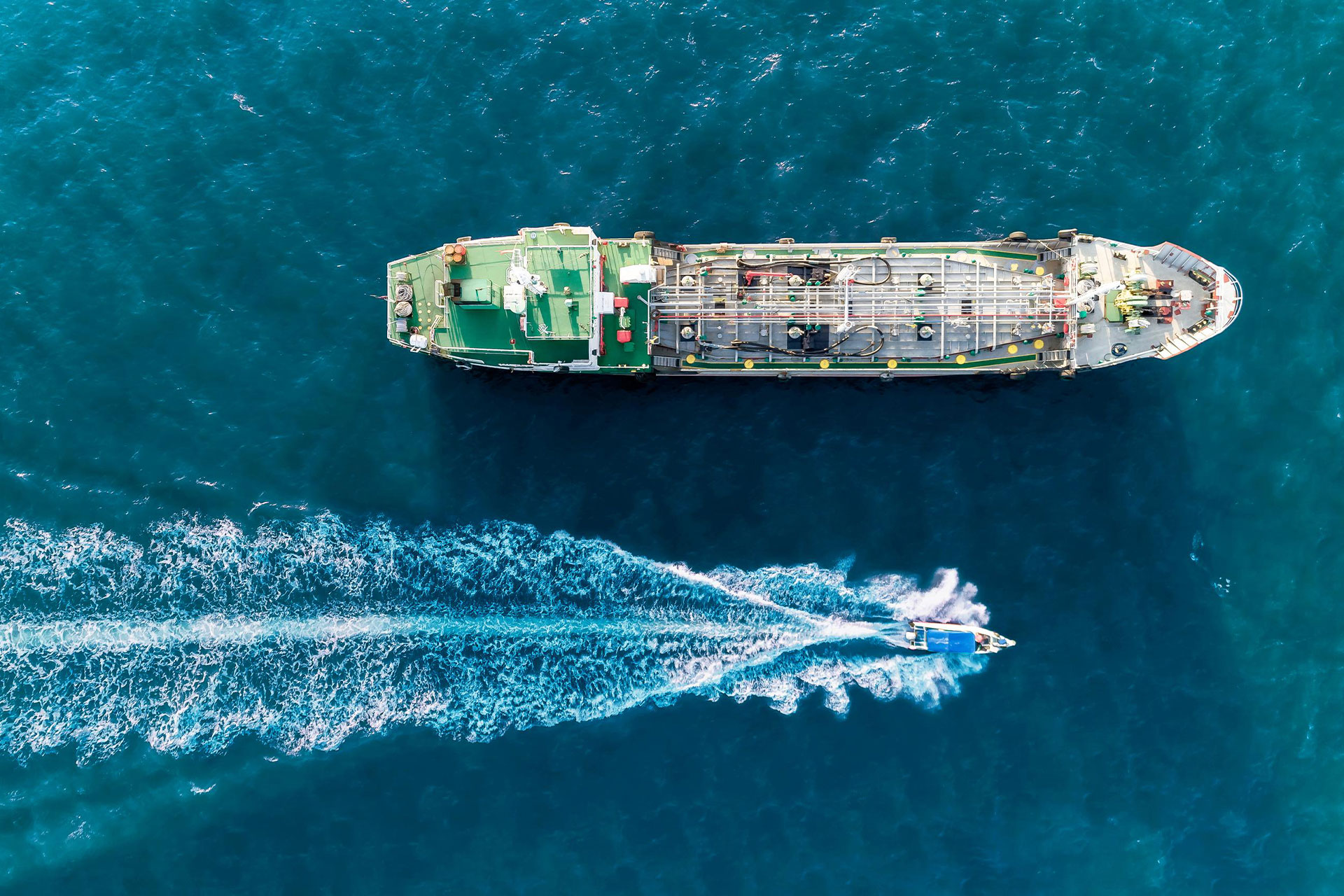 Ein Frachtschiff fährt auf dem offenen Meer und symbolisiert das Outsourcing von Trading Desks im Transaction Banking.