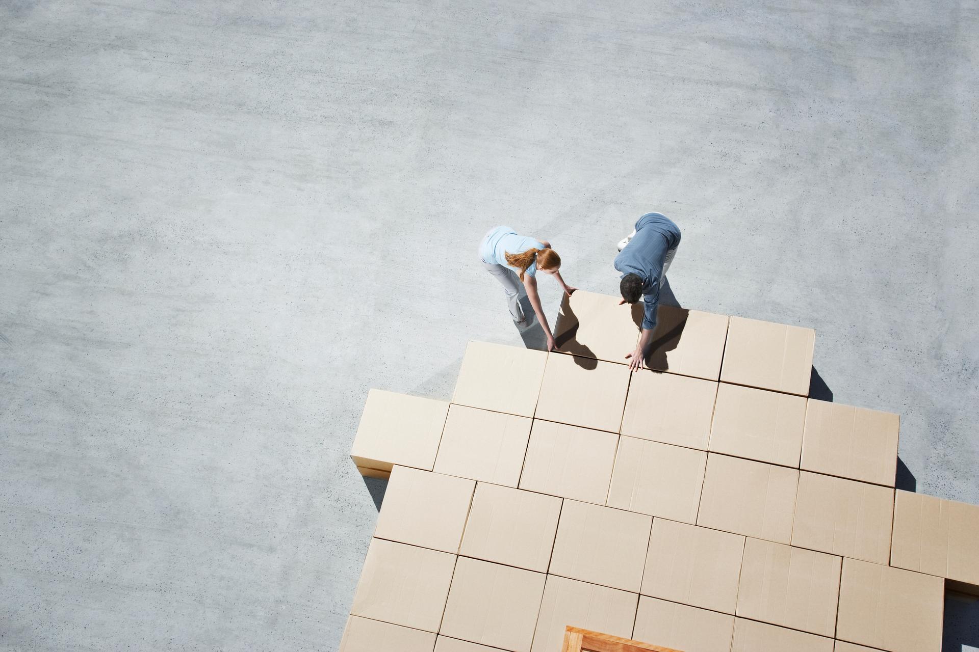 Un homme et une femme se partagent plusieurs cartons entre eux.