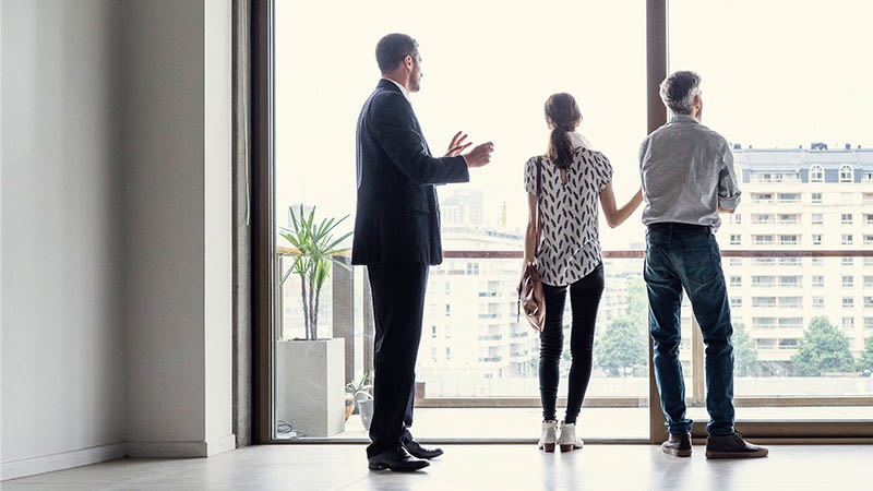 A married couple examines the view of a property, symbolizing a move.