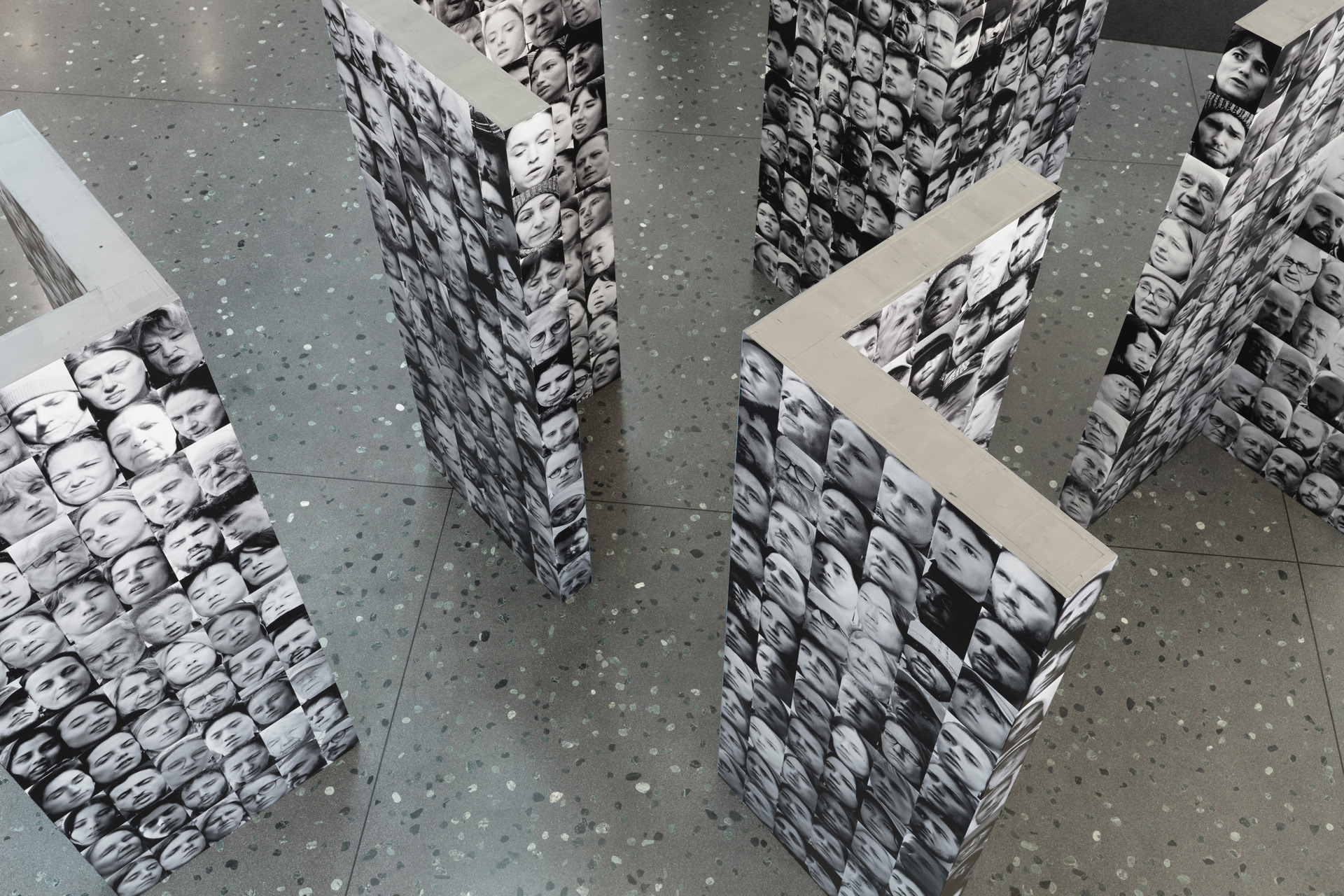 A photo from a bird's eye view: various faces are printed on several columns.