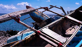 A boat resting on the shore, surrounded by calm waters and a serene atmosphere.