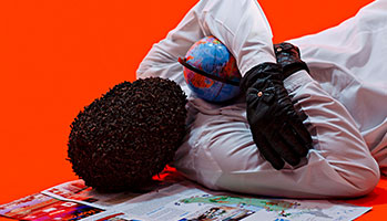 A man laying on his back with a globe between his arms.