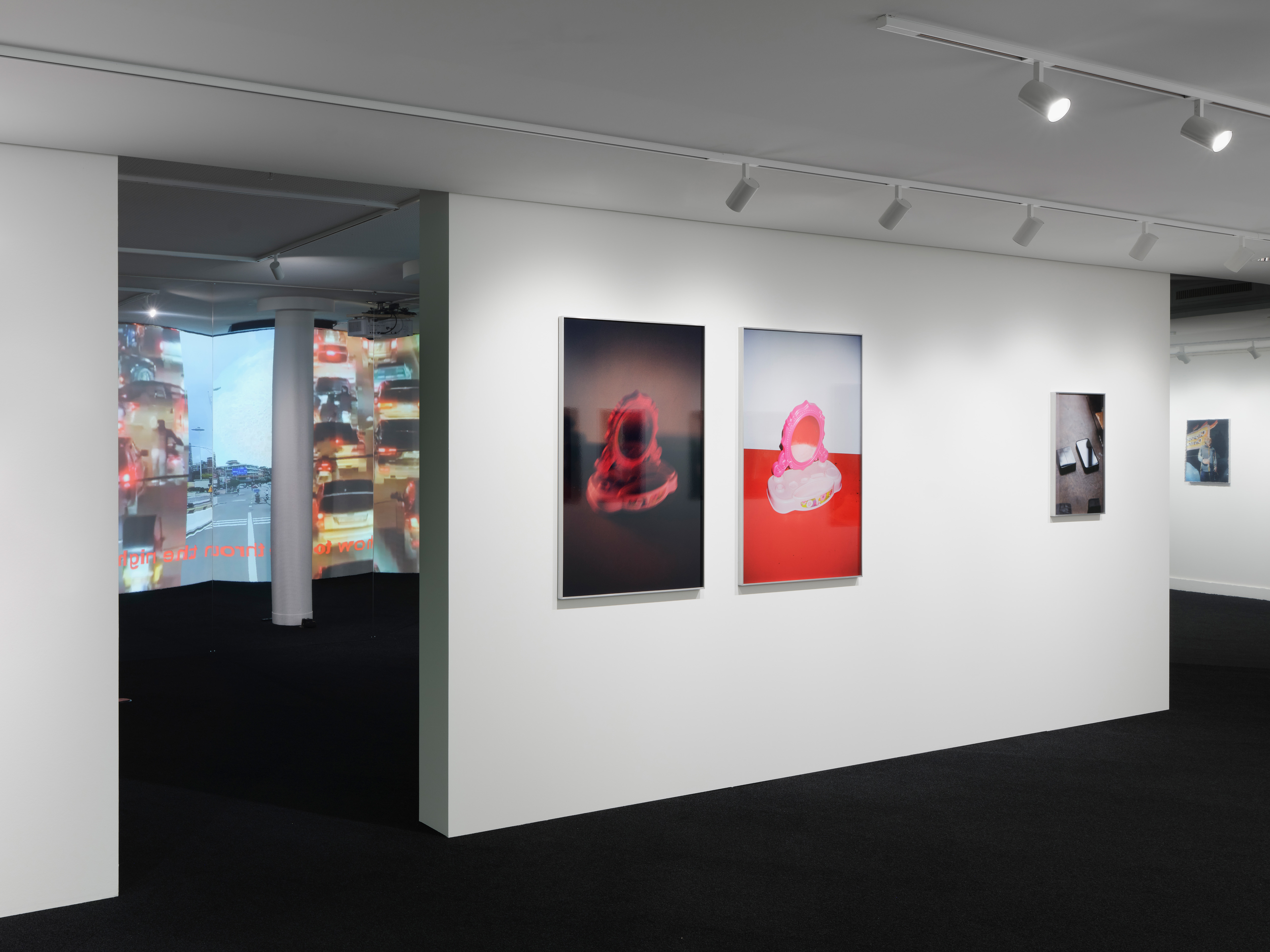 Moderner Ausstellungsraum mit mehreren gerahmten Fotografien an einer weißen Wand