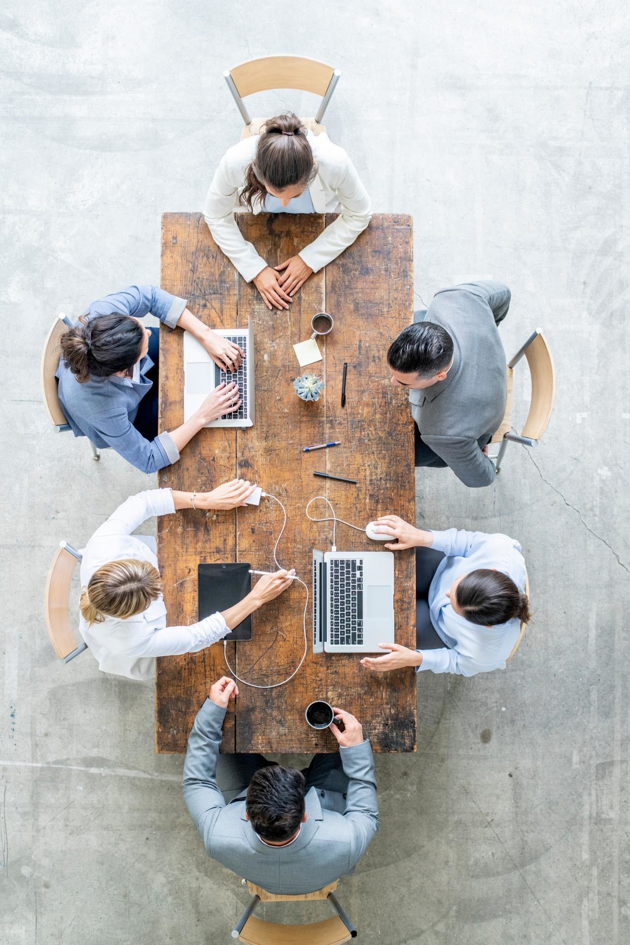 Top down photo of a table where people are sitting and talking working together