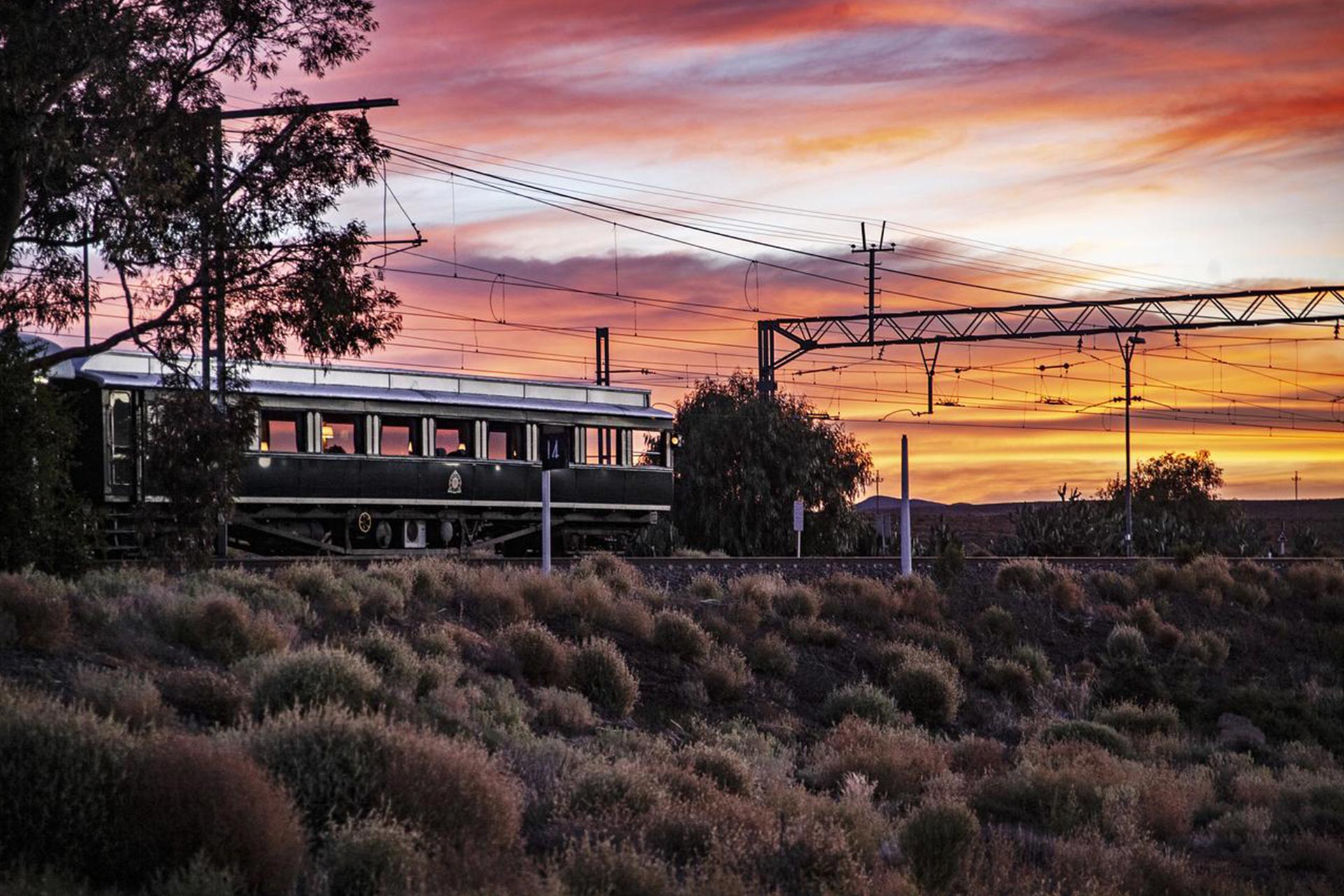 A train entering the station with the sunset in the background.