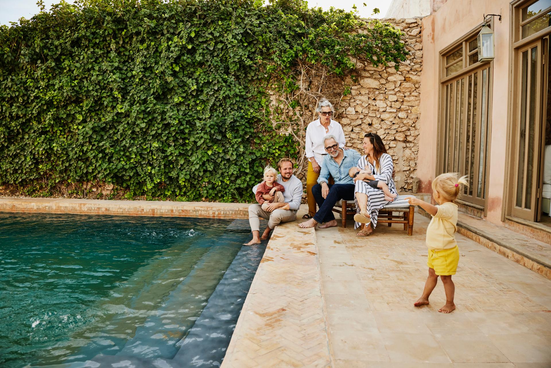 Grandparents, parents, and children gathered by a pool, illustrating that estate division requires proactive planning