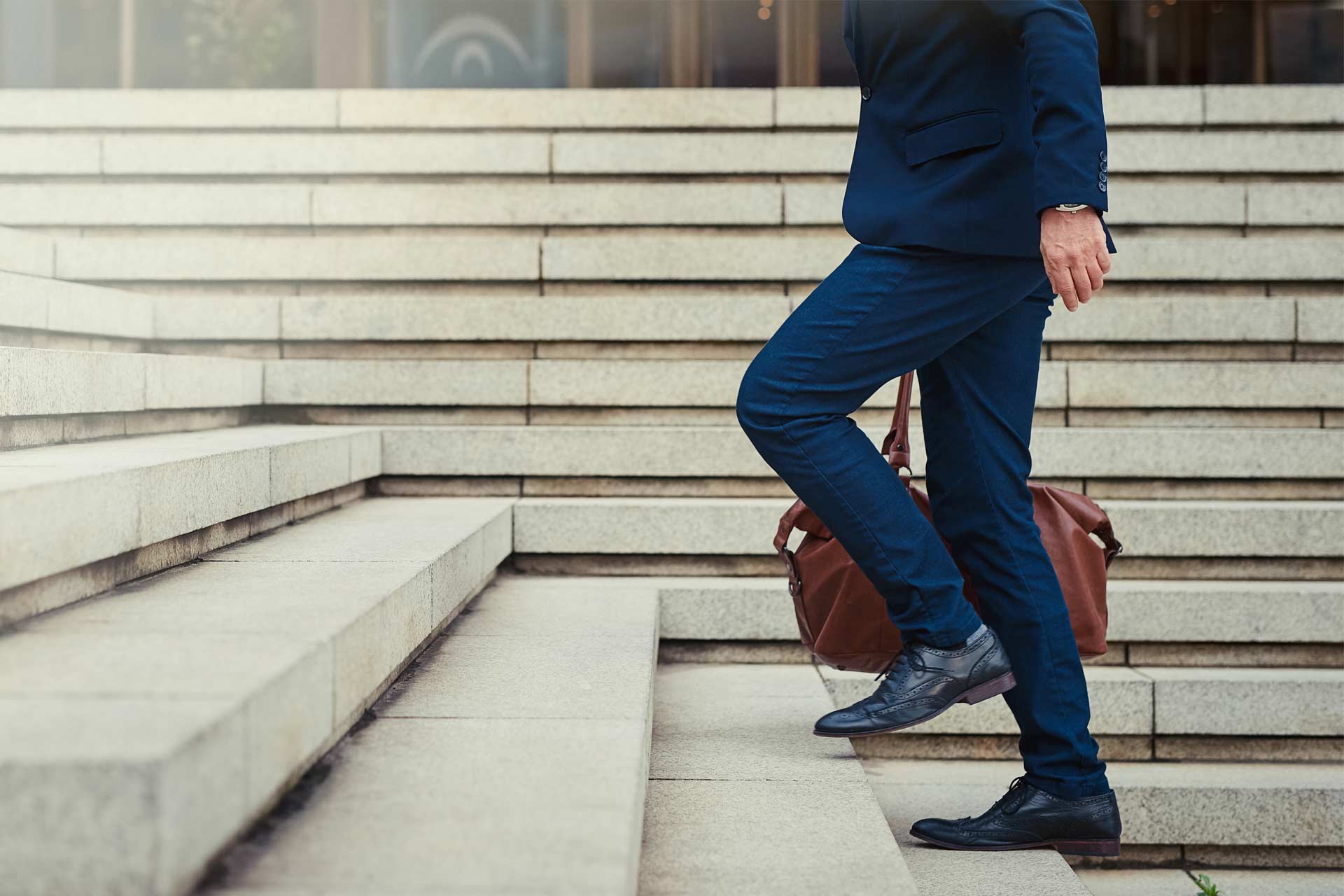 Un uomo d'affari in abito blu sale una scalinata