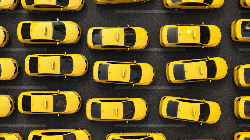 A row of yellow taxis are stuck in a traffic jam