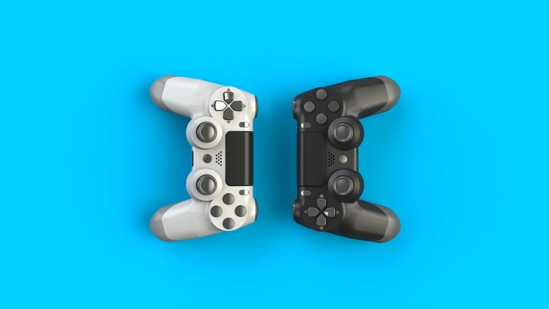 Un controller bianco e nero di una console per videogiochi su uno sfondo blu.