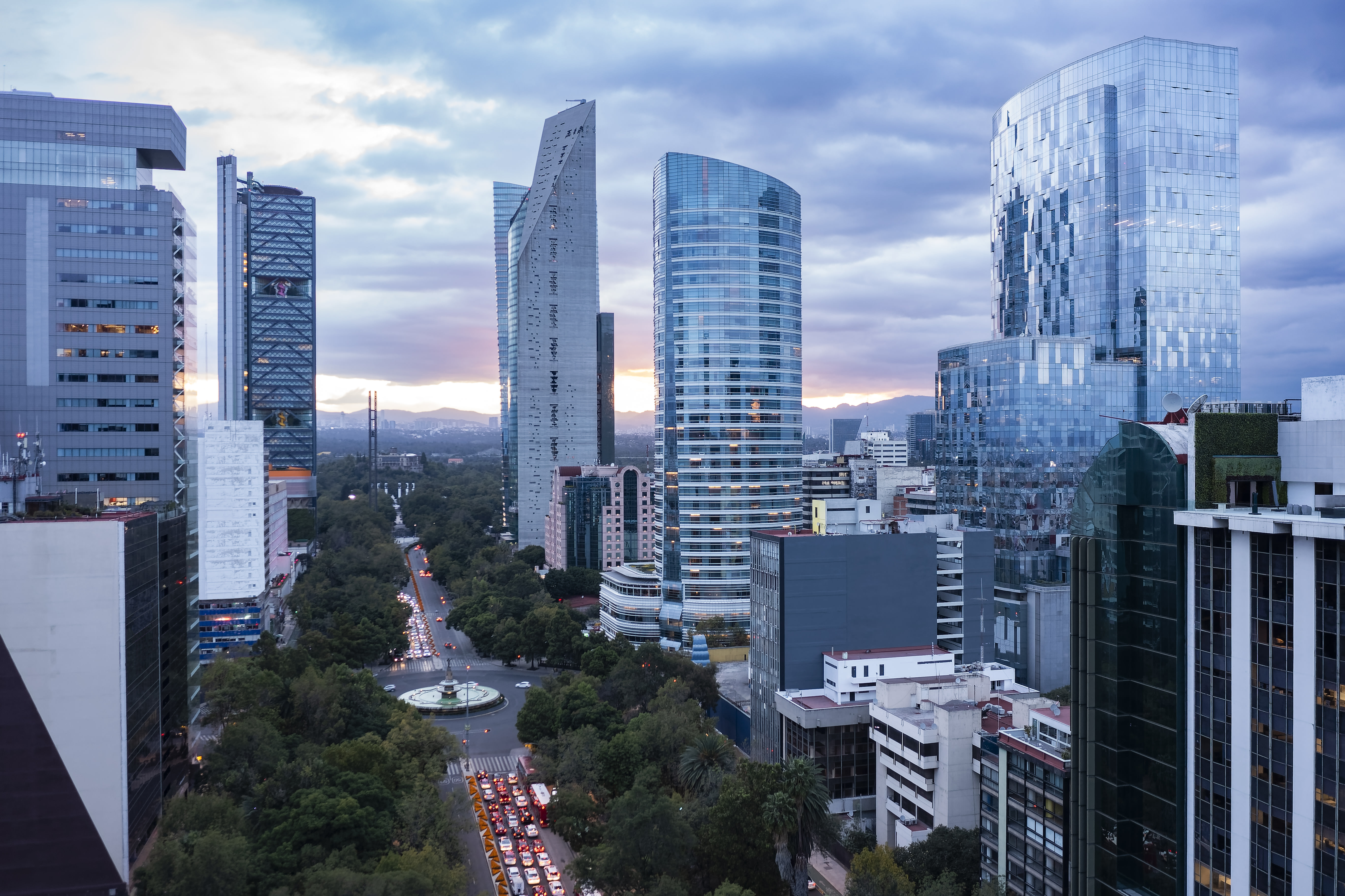 Modern buildings at dusk with illuminated reflections.