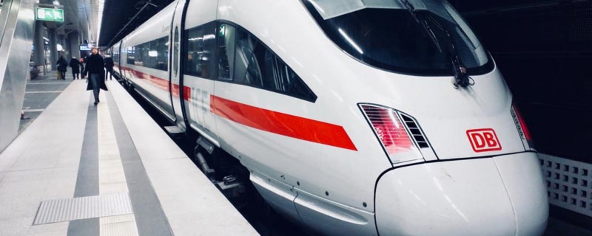 Un treno veloce bianco e rosso parcheggiato in una stazione, pronto a trasportare i passeggeri a destinazione.