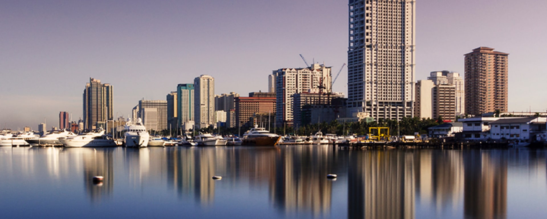 A photo of a city in the Philippines where the sea reflects the skyline.
