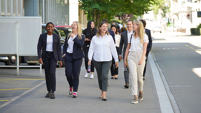 A group of young graduates who work at vontobel walk through the streets of Zurich